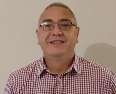 Smiling man in glasses wearing a checkered shirt